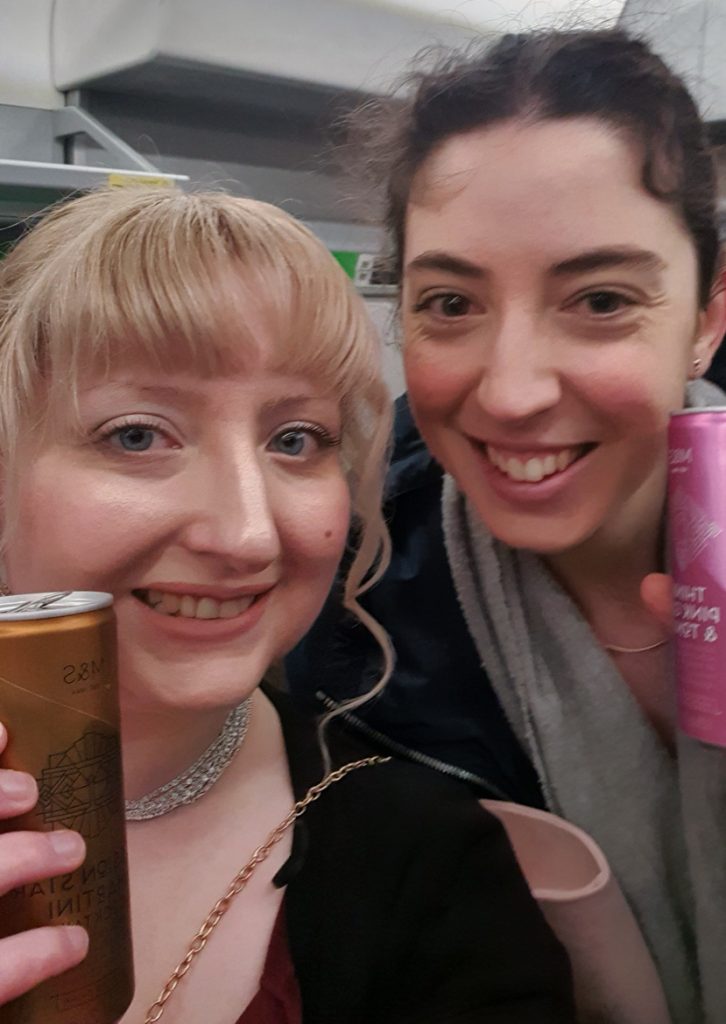 Becky and Matty with a can of cocktail on a crowded train