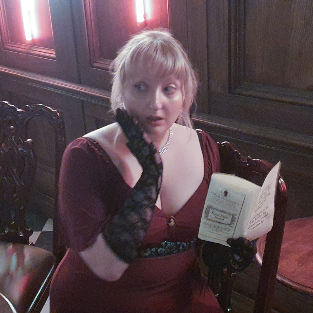 Becky looking shocked at a copy of the Lady Whistledown
