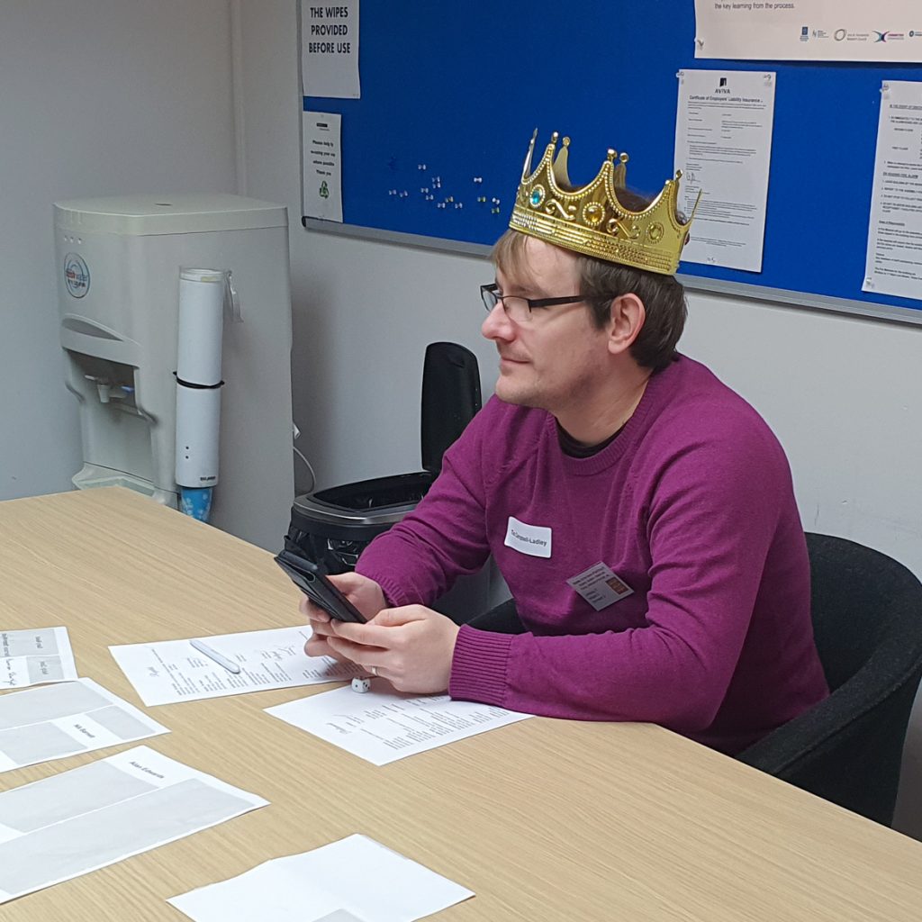 Tim as the King, wearing a Crown, sat nonchalantly