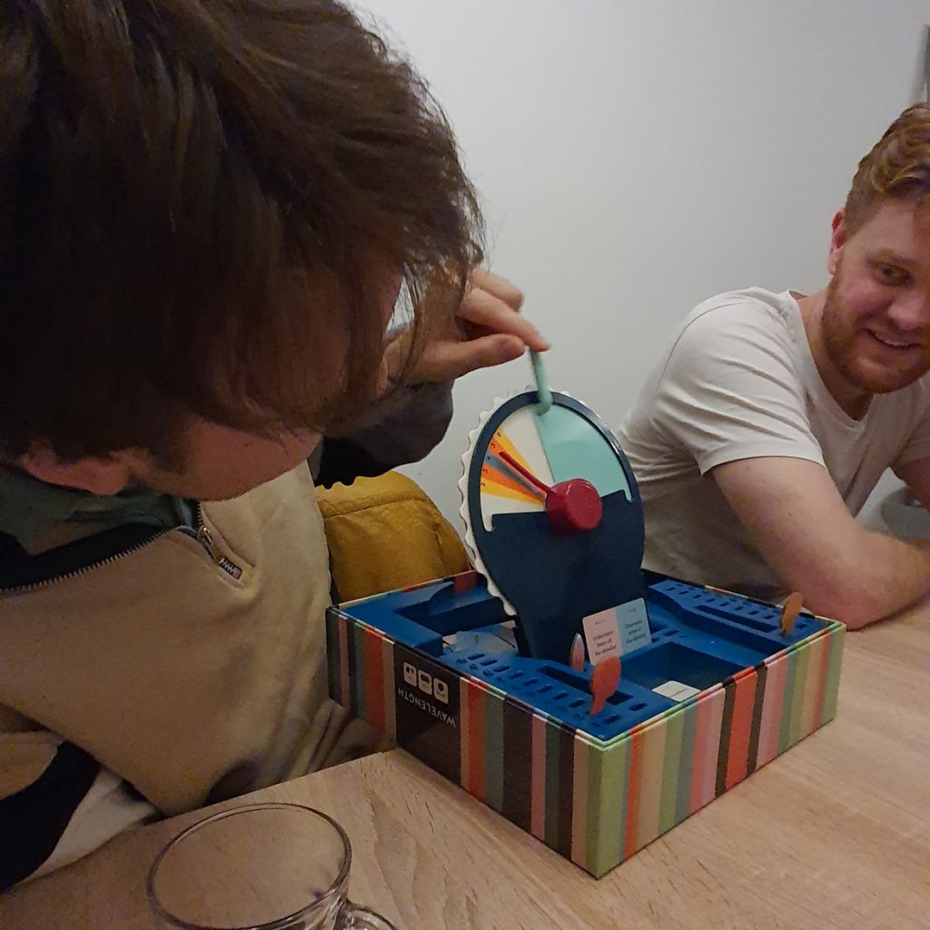 Anthony revealing the scoring system for Wavelength, while Jonty smiles on