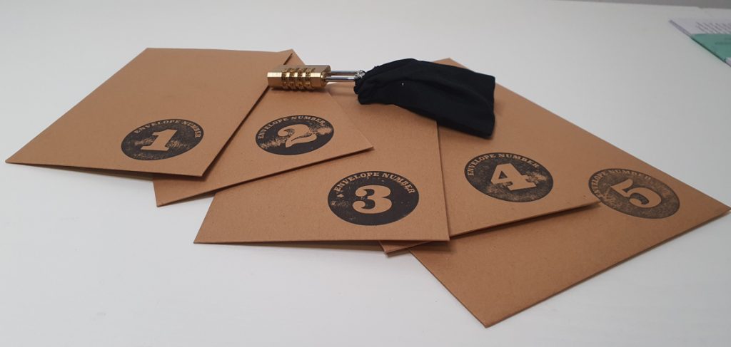 Five envelopes, numbered 1-5, with the black padlocked bag