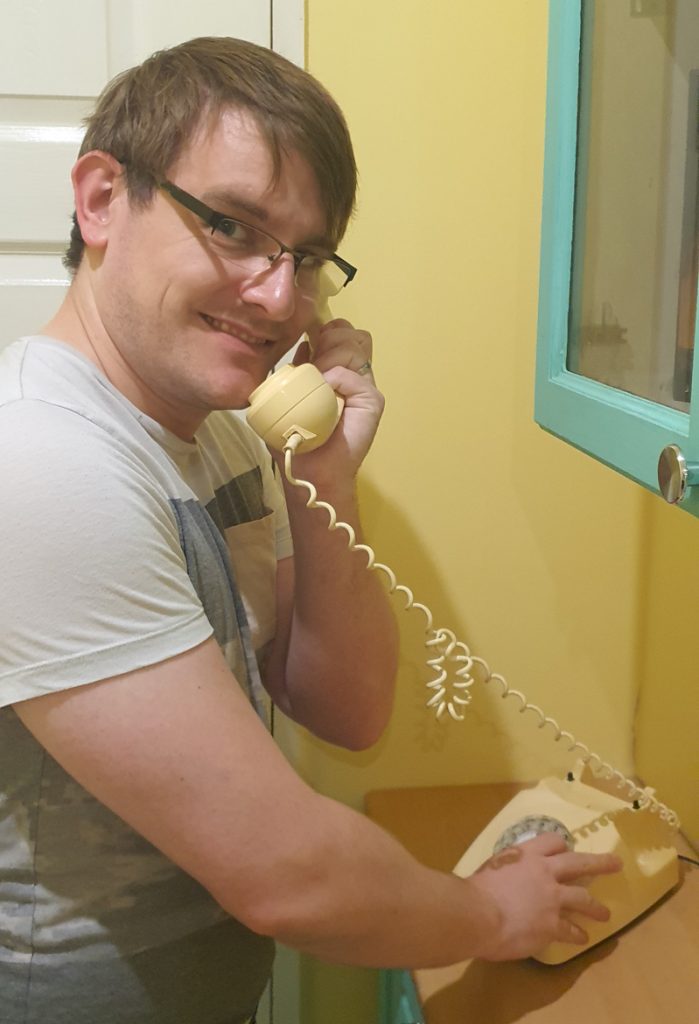 Tim picking up the handset of a rotary telephone