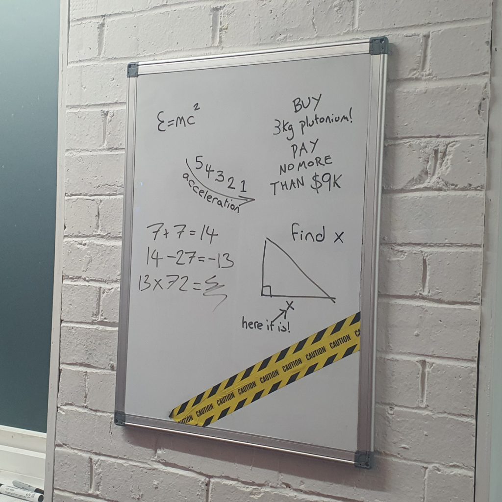 A whiteboard with various mathematical notations and doodles