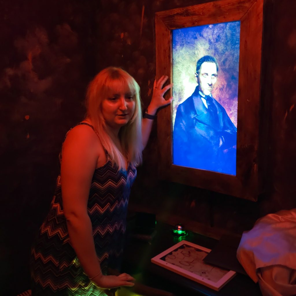 Becky next to a creepy looking portrait of a man in smart clothes