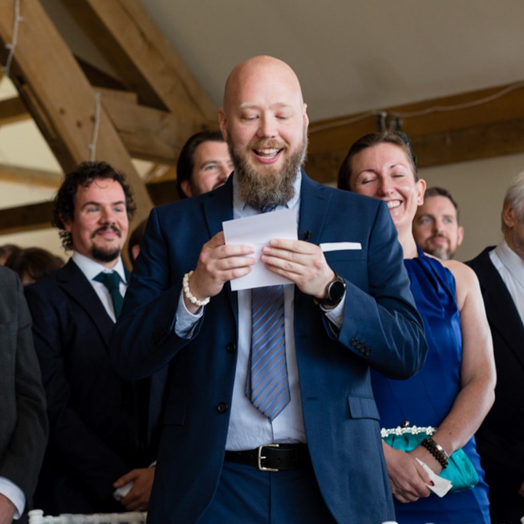 Ed smiling and reading out from a piece of paper