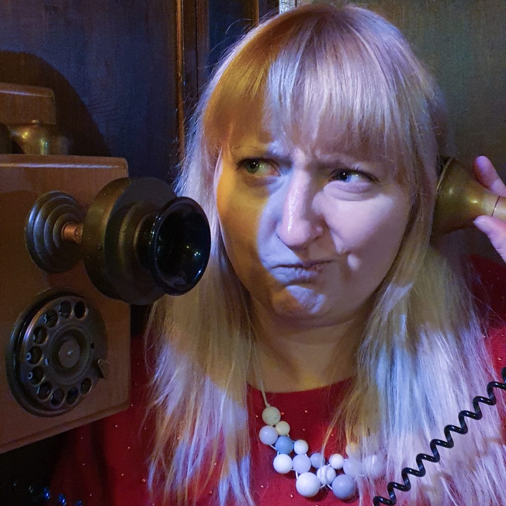 Becky looking perturbed holding an old fashioned phone