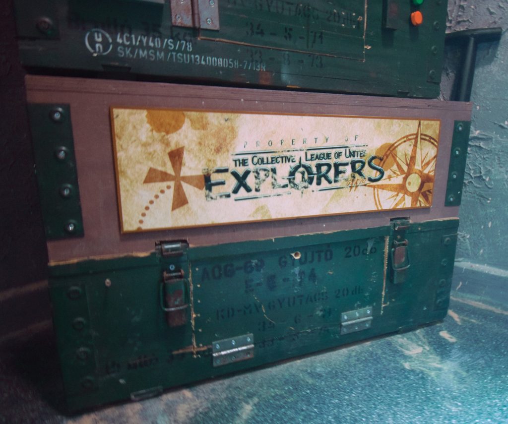 A stack of chests, the middle one reading "Property of the Collective League of United Explorers"