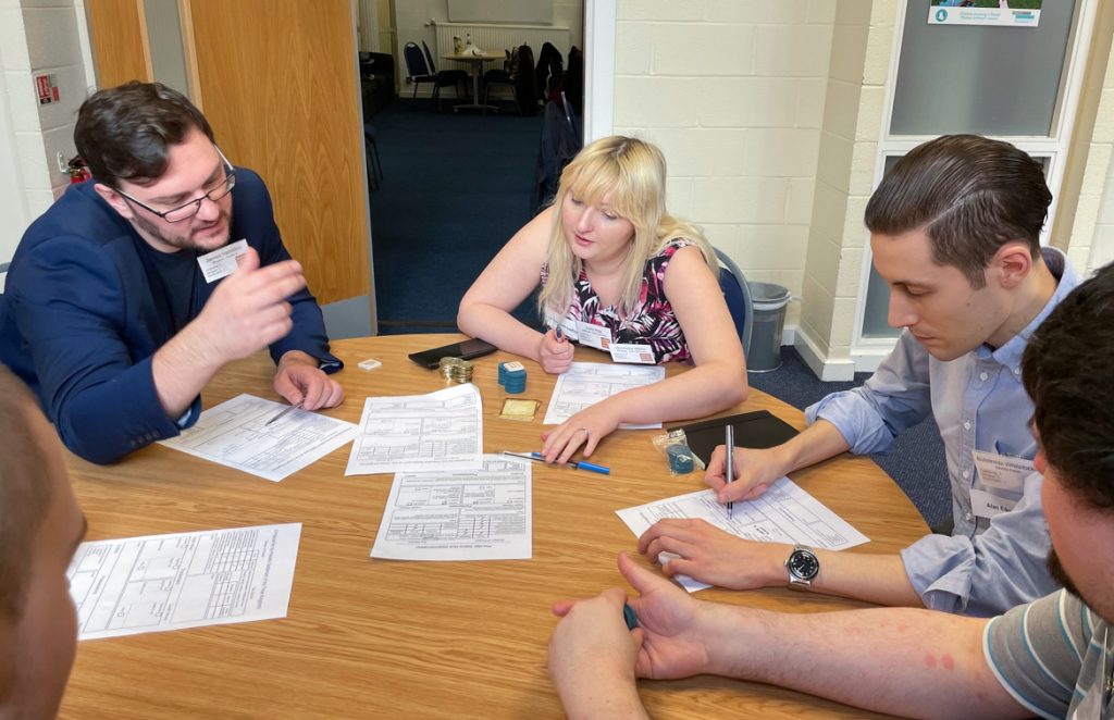 Becky and other players looking over documents