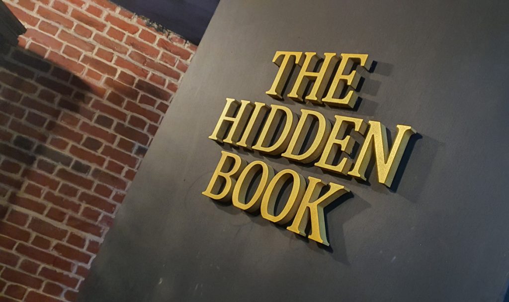 A door with a sign reading "The Hidden Book"