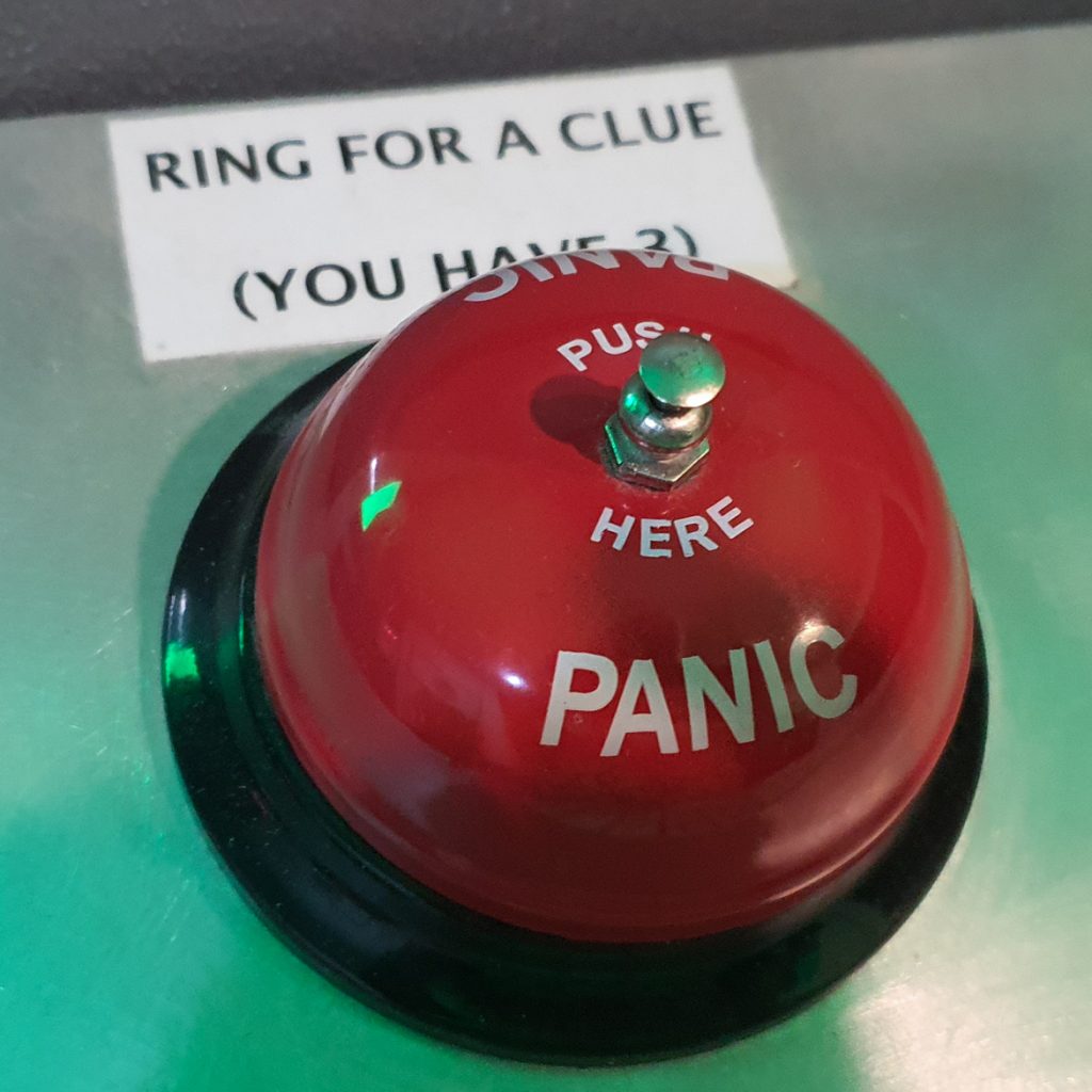 A bell reading "Don't Panic" with a sign saying to ring for a clue (you have 3)