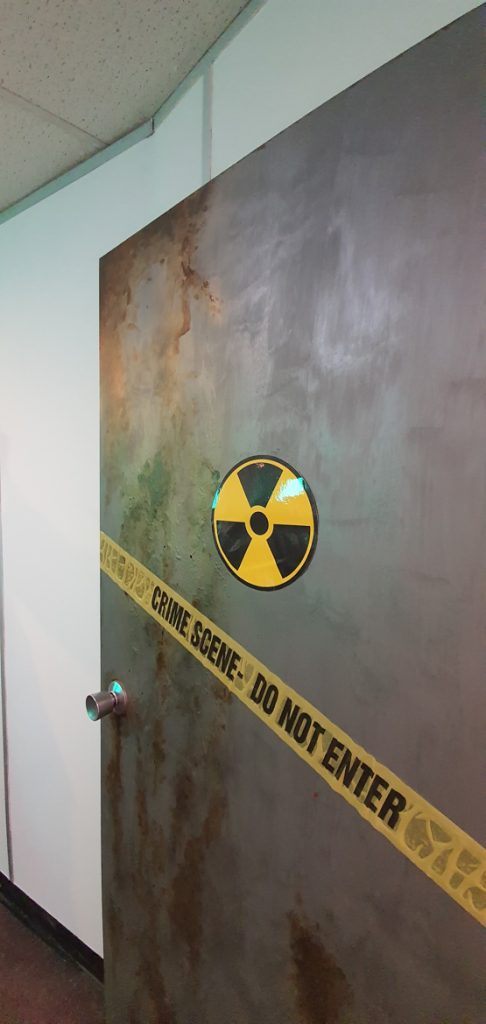 The door to The Machine, featuring a radiation sign and "Crime Scene - Do Not Enter"