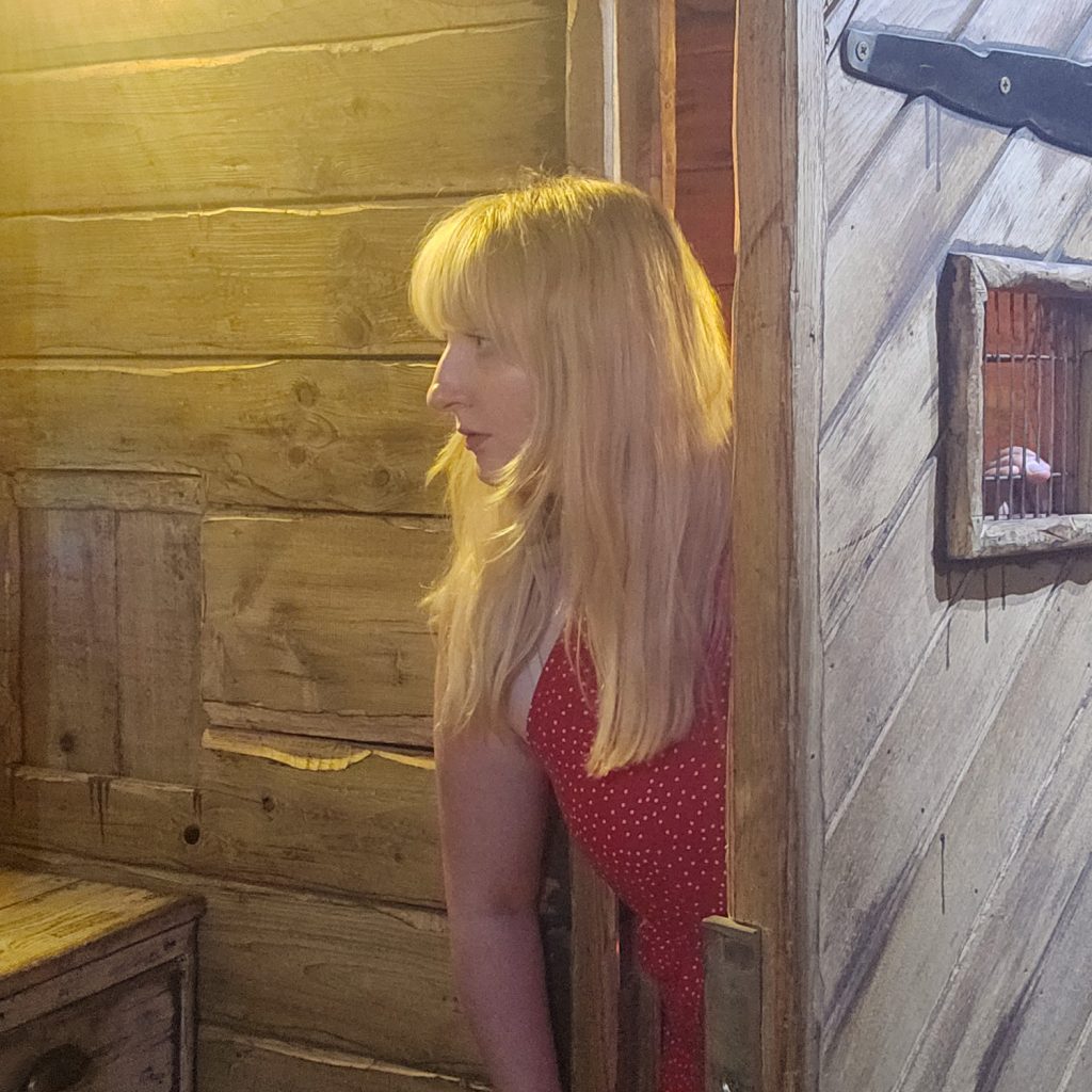 Becky leaning out of a door in the Dodge City escape room by Tulleys Farm