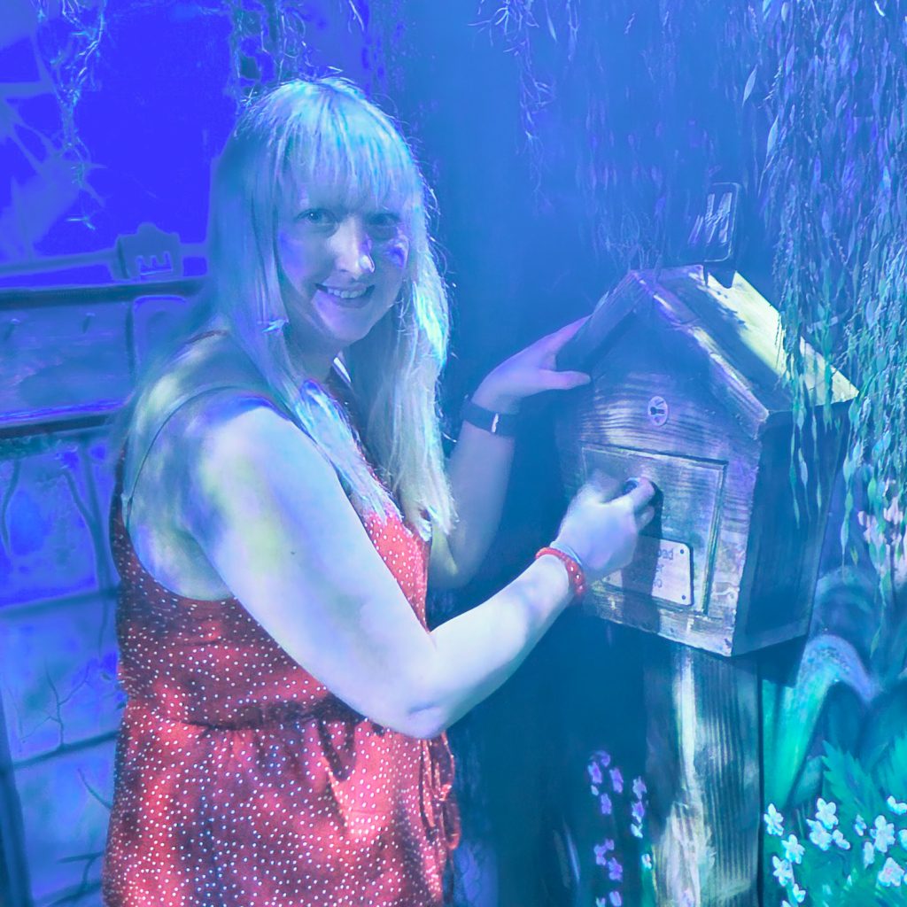 Becky inspecting a mailbox at the Nethercott Manor escape room by Tulleys Farm