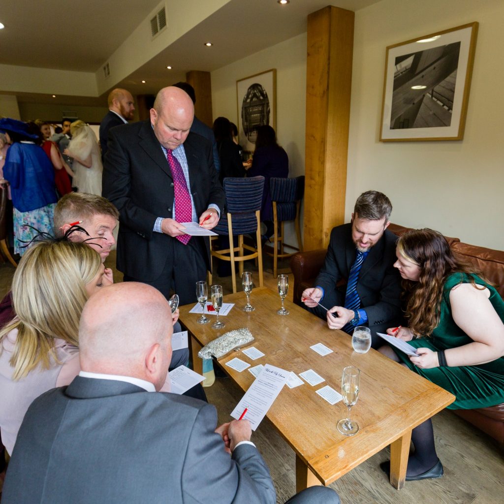 Wedding guests looking at pieces of paper which are part of the "Theft at the Ticky Museum" game
